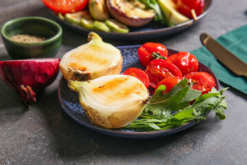 Plate with tasty grilled vegetables on dark background