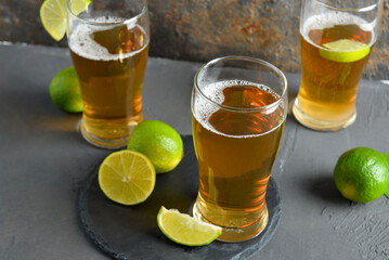 Glasses of cold beer with lime on table