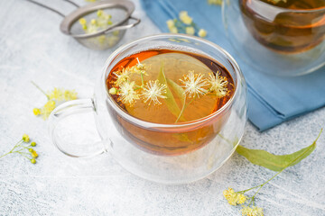 Glass cup of linden tea on white background