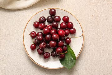 Plate with sweet cherries on white background