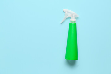 Spray bottle of detergent on blue background