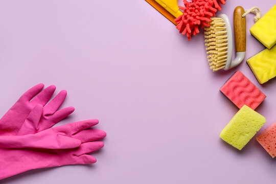Frame made of different cleaning supplies on lilac background - Powered by Adobe
