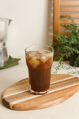 Pouring espresso from moka pot into a glass with tonic