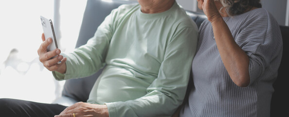 Embraced mature couple surfing the Internet on laptop at home