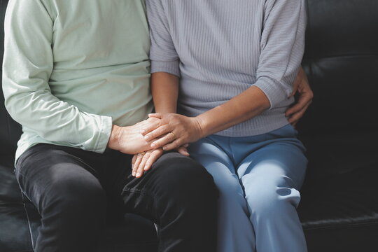 Embraced mature couple surfing the Internet on laptop at home