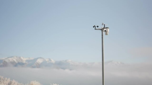 Pole Mounted Weather Station In Front Of Majestic Snowy Mountains