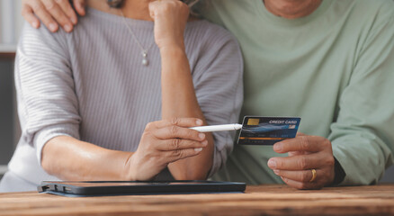 Close up mature man holding plastic credit card, senior couple family paying online, using laptop, satisfied older customers making secure internet payment, shopping, browsing banking service