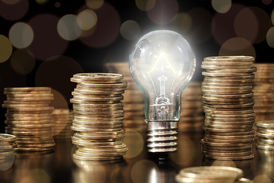 Financial literacy image. Knowledge of managing money. Lightbulb and stack of coins.