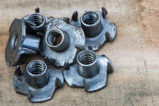 T nut, tee nut, blind nut, flush fitting, pronged nut, used to mount materials to a work piece leaving a flush surface, woodworking, joint with selective focus