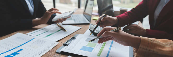 Businesswoman teamwork discussing brainstorming and calculating with calculator on evaluation data in conference room Focus on business growth and point out financial accounting charts.