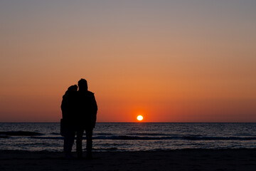 couple in love watching the sunset over the sea