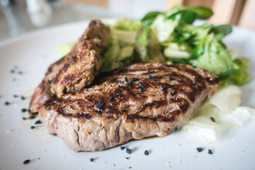 A beef steak with green salad closeup