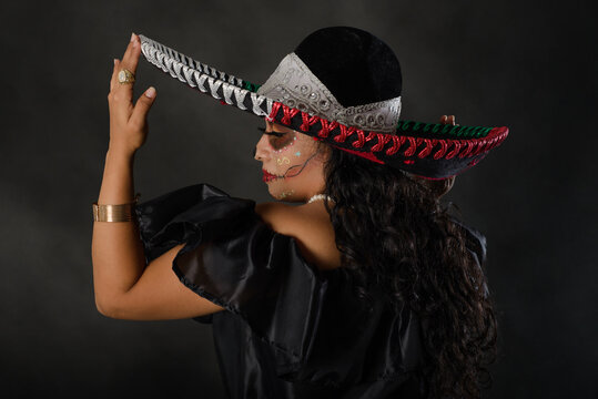 Catrina wearing a mariachi hat with the colors of the Mexican flag. Day of the dead celebration.