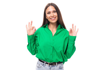 portrait of a confident smiling young european brown-eyed female model with well-groomed black hair and makeup dressed in a green shirt