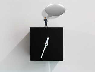 One successful business man giving advice while standing on a wall clock.