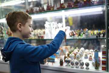 Child choosing souvenir in shop window