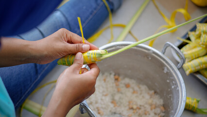 The process of tying coconut leaves as a snack pack is called lepet. Lepet is a traditional food made from white glutinous rice, grated coconut and peanuts