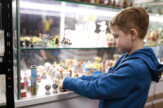 Boy choosing souvenir in shop window