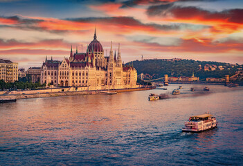 Old pleasure boats on Dunabe river with Parliament house on background. Stunning summer cityscape of Budapest. Amazing sunset in Hungary, Europe. Traveling concept background. - obrazy, fototapety, plakaty