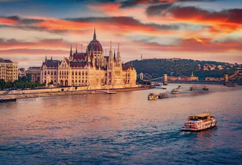 Poster Old pleasure boats on Dunabe river with Parliament house on background. Stunning summer cityscape of Budapest. Amazing sunset in Hungary, Europe. Traveling concept background. © Andrew Mayovskyy