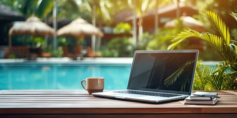 Work by the poolside. With laptop on wooden table. Technology and business for work where notebook opens up view to relax holiday. Lifestyle, travel, and digital freelancing by cup of coffee