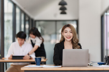 Fototapeta na wymiar Smiling Asian Accountant person analyze financial report and studies annual figures, analyzes profits