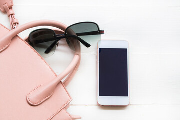 mobile phone, pink hand bag and sunglasses accessories of lifestyle woman arrangement flat lay...