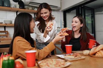 Happy friends laughing and having party at kitchen room at house