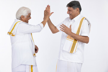 Two south indian happy senior men embracing each other isolated on white background.
