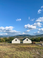 Fototapeta na wymiar Two farmhouses and the fields between the mountains 
