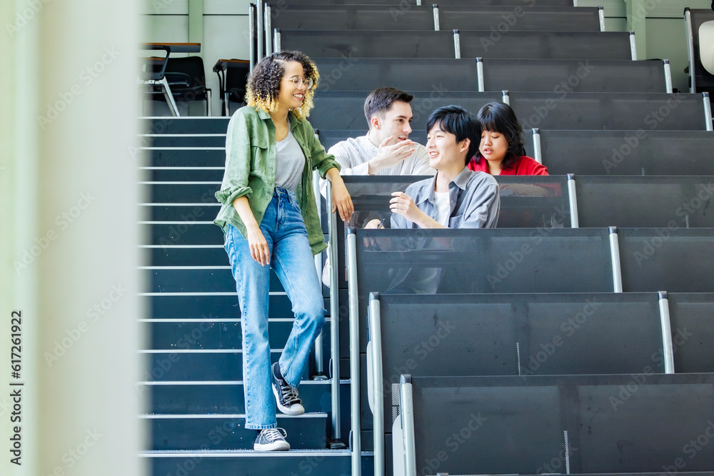 Poster group of multinational students having a conversation in a classroom.