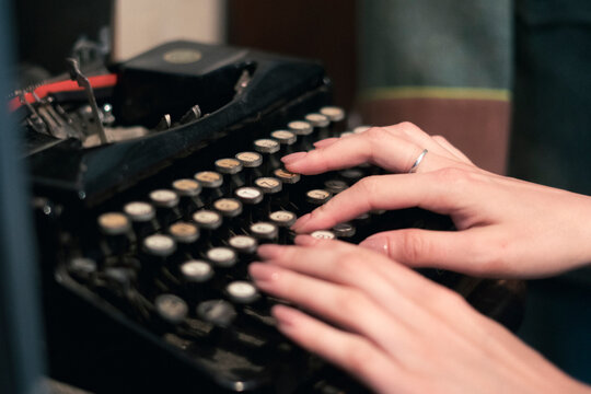 female person typing text using and old typewriter machine