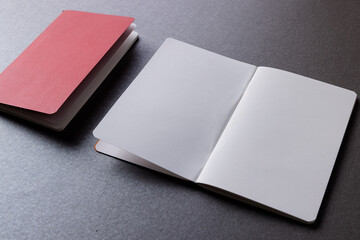 Close up of red notebook and open book with copy space on grey background