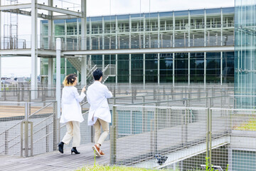 A multinational group wearing a white coat and walking through a facility.