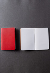 Close up of red notebook and open book with copy space on grey background