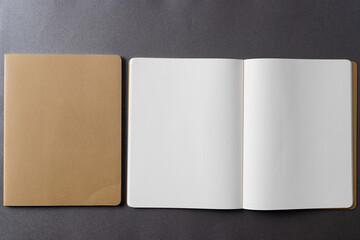 Close up of beige notebook and open book with copy space on grey background