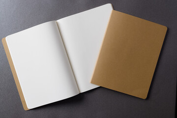 Close up of beige notebook and open book with copy space on grey background