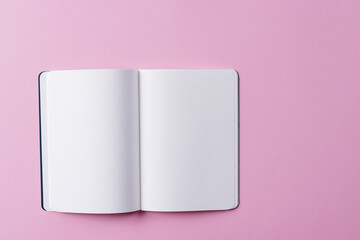 Close up of open book with copy space on pink background