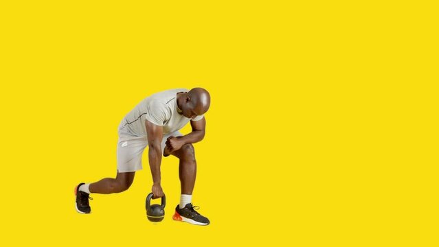 Sportive african man doing exercises of row stoke with kettlebell