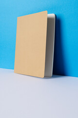 Close up of beige notebook with copy space on blue background