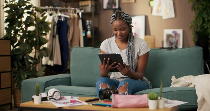 African software developer, specializing in mobile app development uses tablet to test debug applications, review code, and stay up-to-date with the latest industry news and programming languages.