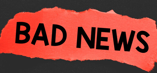 BAD NEWS word written on a red piece of paper.