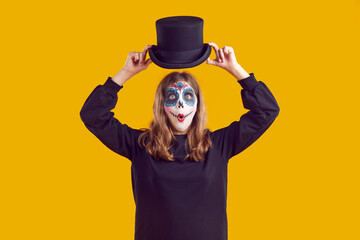 Funny child in Halloween costume. Little girl with Catrina skull make up standing isolated on...