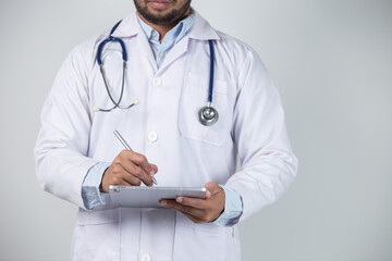 Close up of male doctor using digital tablet over gray background. Medical and healthcare concept.