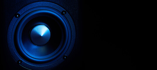 Multimedia acoustic sound speakers with blue neon lighting. Sound audio system on dark background...