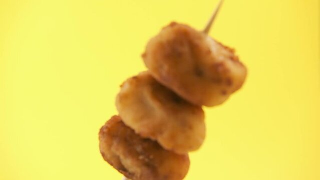 croquettes on a pincho on yellow background isolated