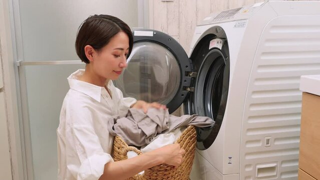洗濯機から洗濯物を取り出すミドルエイジ女性