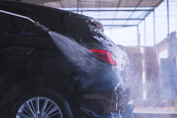 Car washing cleaning car using high pressure water background

