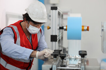 Fototapeta na wymiar Caucasian mechanic technician maintenance, repairing industrial machinery equipment in factory. Professional worker in protective clothing with goggles and mask using wrench at manufacturing factory