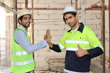 Two technician civil engineer or specialist inspector give high five celebrate successful together completed deal commitment at Industrial building site. Construction concept